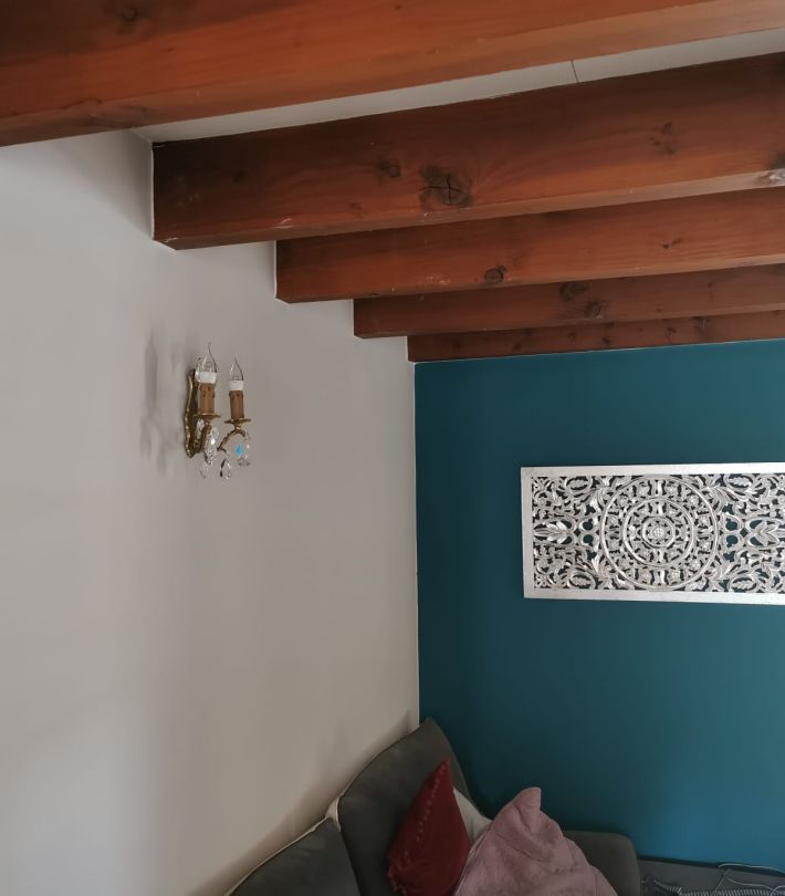 Application de peinture mate couleur ivoire sur le mur principal d’un salon à Toulouse